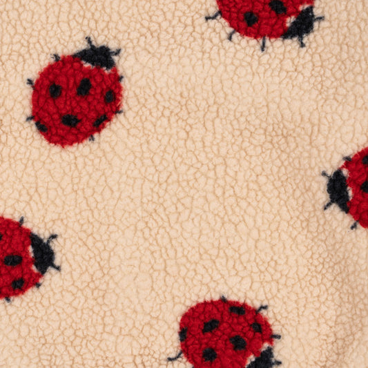 A detailed look at the irresistibly soft teddy fleece, covered in Konges Sløjd’s signature ladybird print. Perfect for snuggly days and wild adventures.