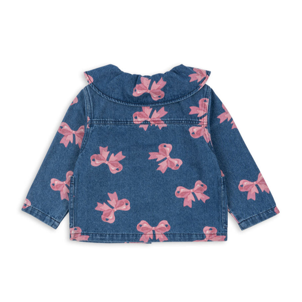 A full view of the Konges Sløjd Magot Collar Jacket from the back, showcasing the ruffled collar, long sleeves, and all-over pink bow print on blue denim.