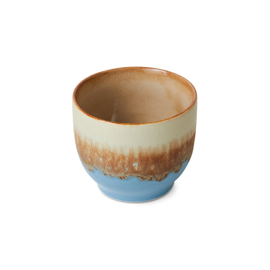 Ceramic cup with gradient brown to blue design on a white background
