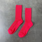 Two red socks on a gray concrete surface