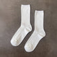 Two white socks on a brown surface