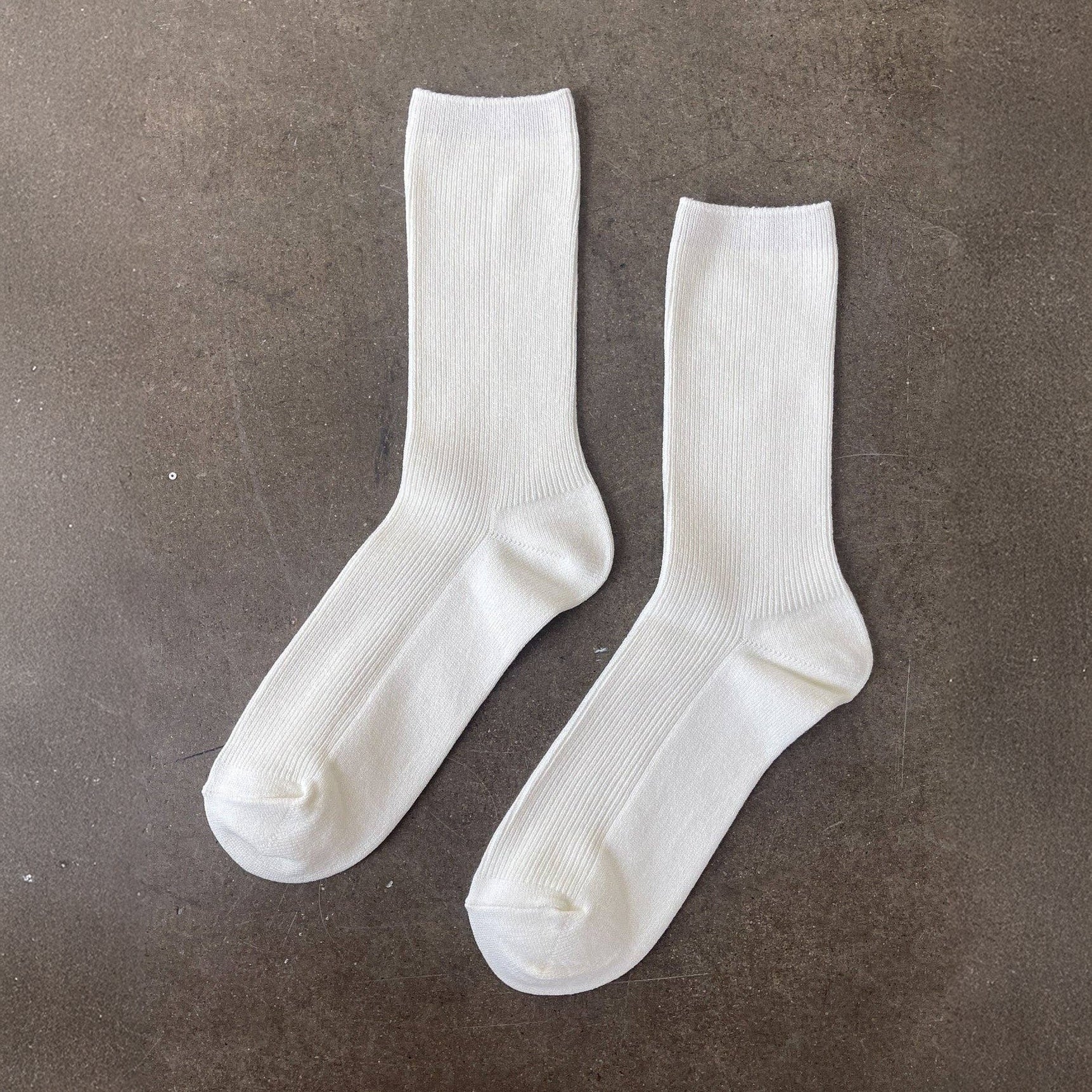 Two white socks on a brown surface