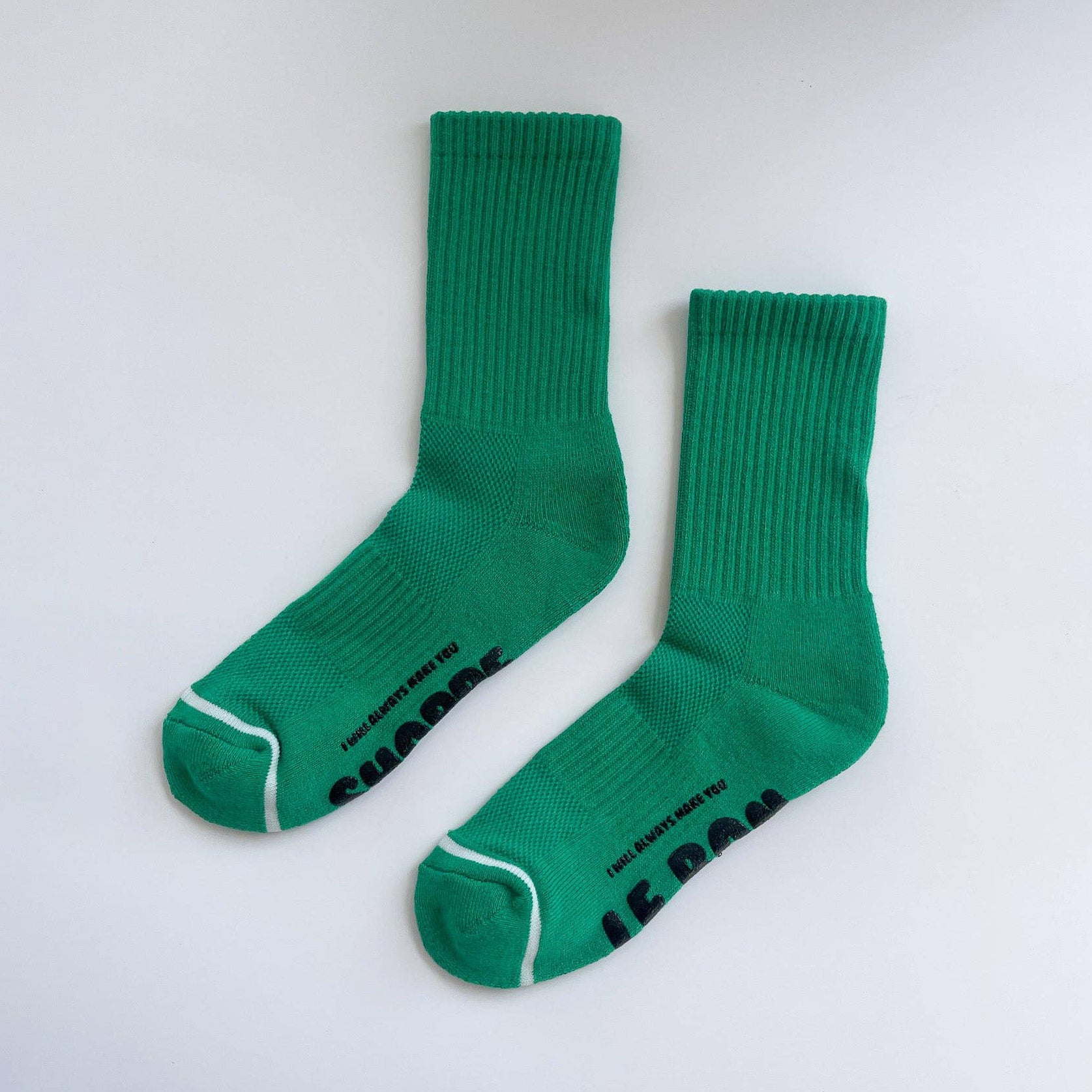 Pair of green socks with white accents on a light gray background