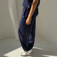 Person wearing navy blue wide-leg pants and silver shoes on a neutral background