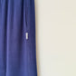 Blue pant leg with a small white label on a beige background