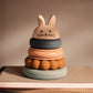 Colourful stacking toy with a rabbit-shaped top on a neutral background