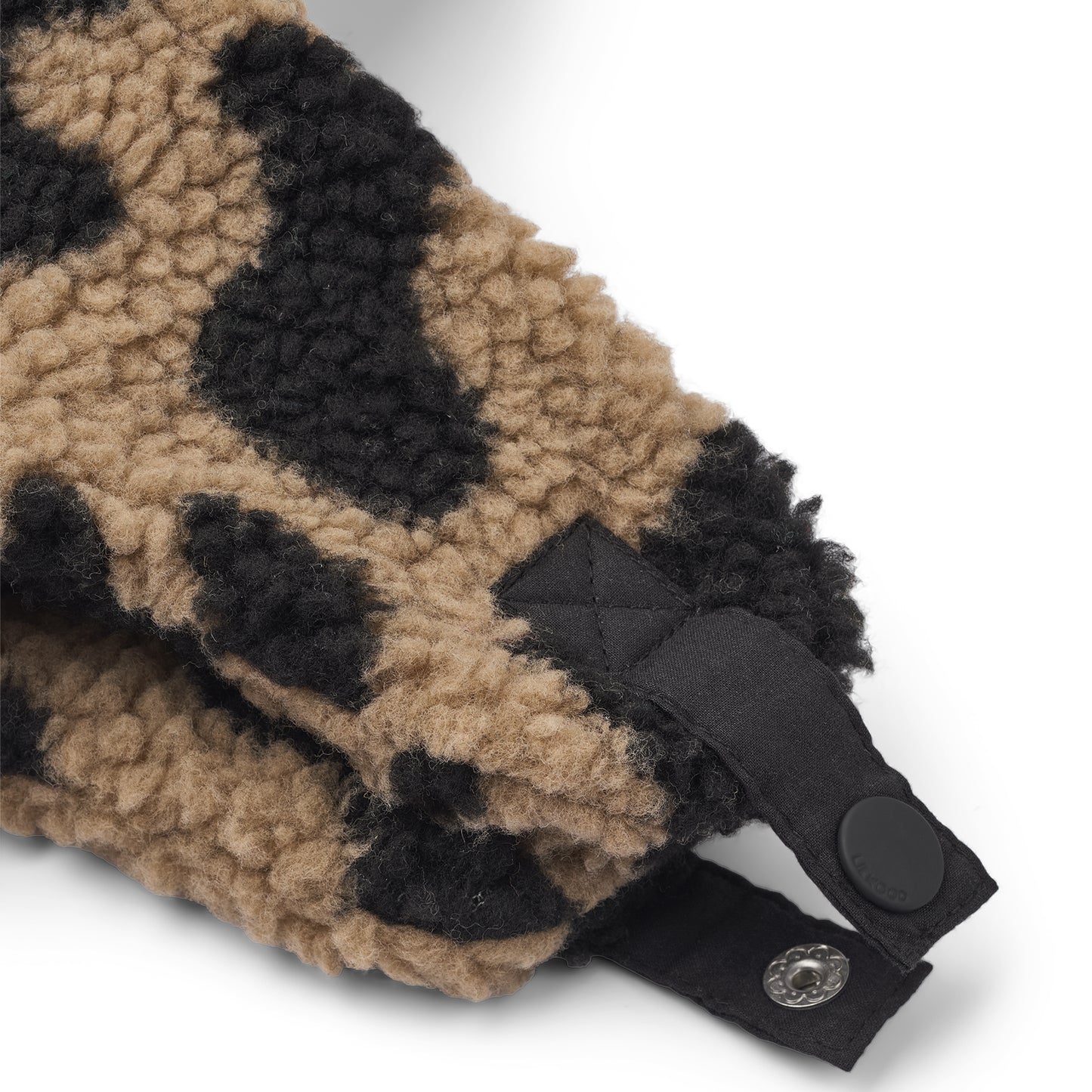 Close-up of a leopard print headband with a black strap and button on a white background