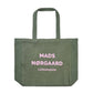 Green tote bag with 'Mads Nérgaard Copenhagen' pink text on a white background