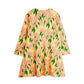 Floral dress with pink flowers and green leaves on a yellow background, viewed from the back