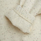 Close-up of textured fabric with a ribbed trim on a light background