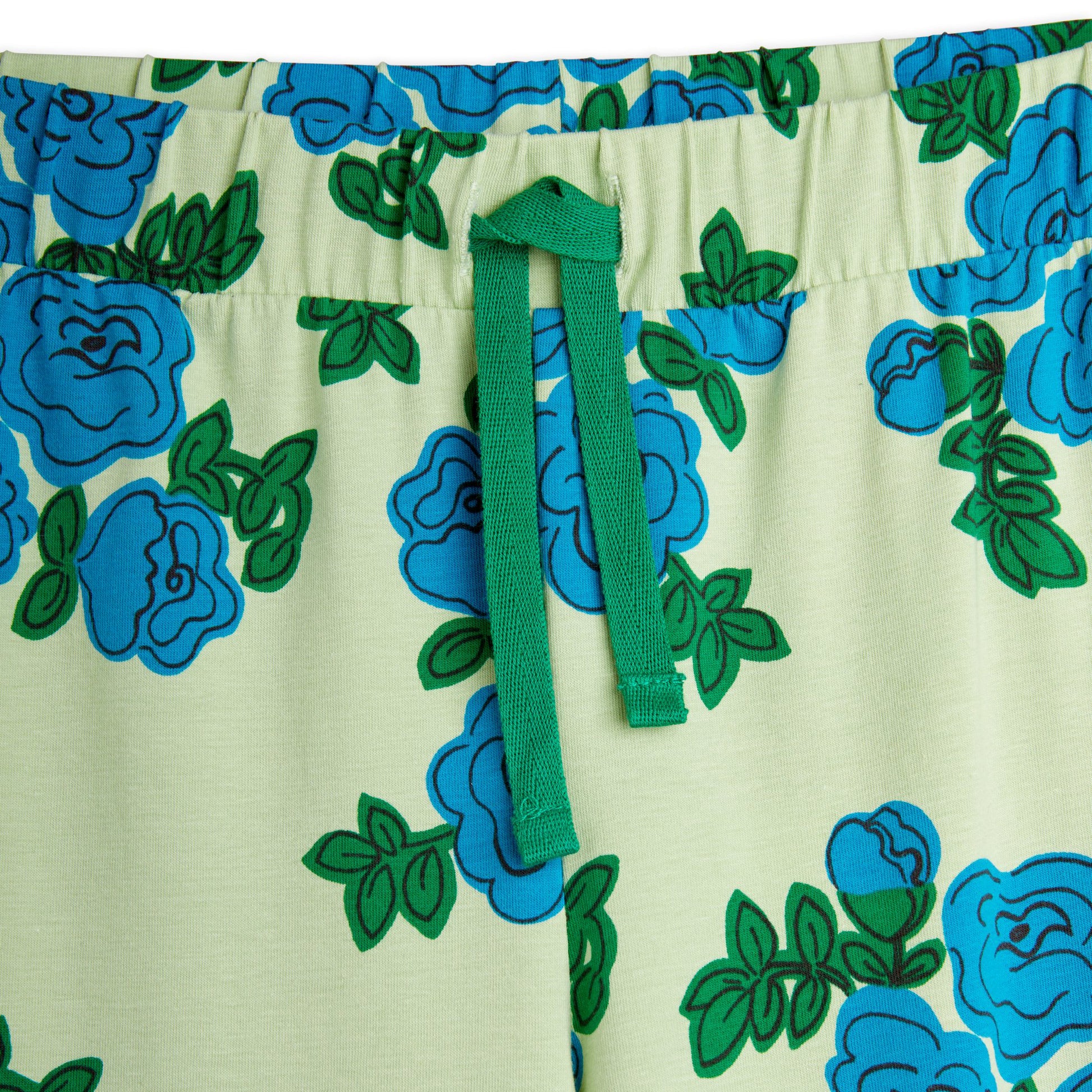 A detailed close-up of the elasticated waistband with a green drawstring, highlighting the intricate blue floral pattern and soft fabric texture.