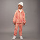 Child wearing a red and white checkered outfit with a gray background