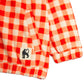 Red and white checkered fabric with a black and white label featuring a cat icon on a white background