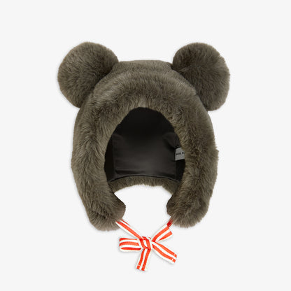 Brown fuzzy hat with bear ears and a red bow on a white background