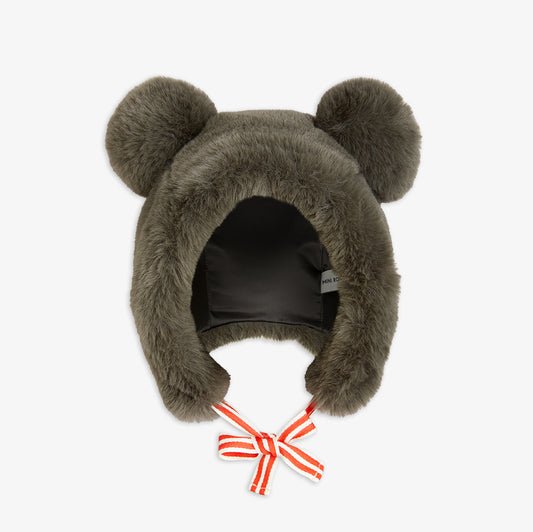 Brown fuzzy hat with bear ears and a red bow on a white background