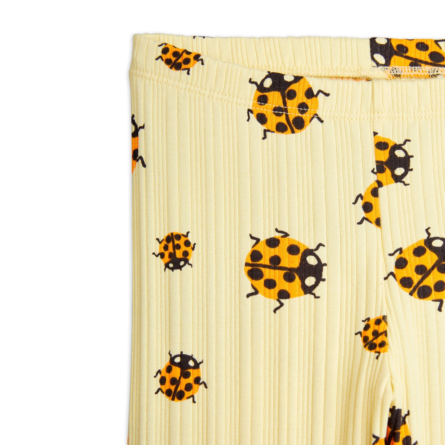 A zoomed-in view of the ribbed fabric texture of the leggings, highlighting the orange and black ladybird pattern.