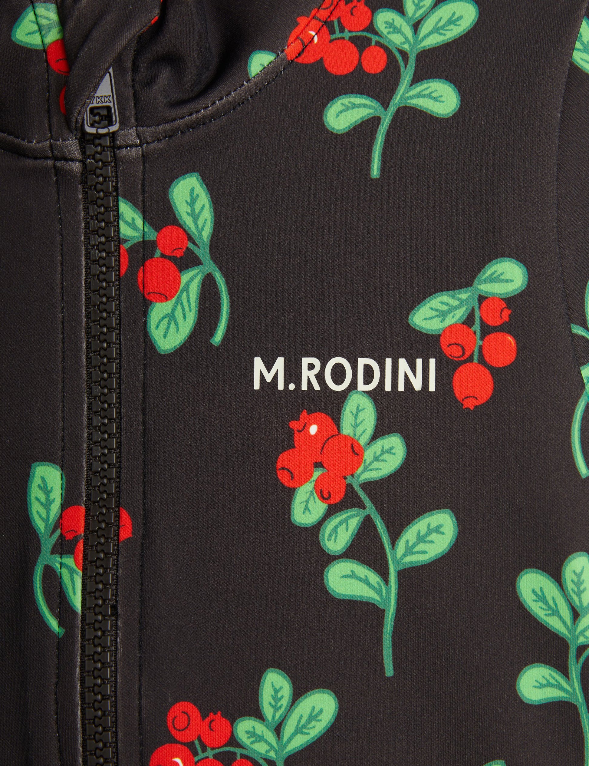  detailed close-up of the "M. Rodini" logo, front zip, and vibrant red berry print on the swimsuit's smooth, stretchy fabric.