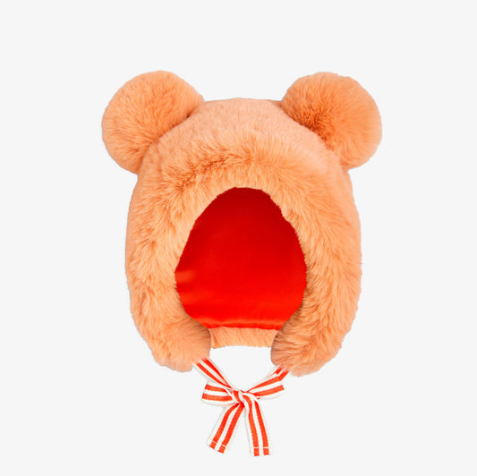 Peach-colored plush hat with bear ears and a red interior on a white background