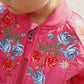Close-up of a pink jacket with floral embroidery