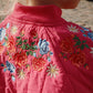 Close-up of a pink garment with floral embroidery