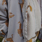 Gray jacket with tiger pattern and white scarf worn by a person outdoors.