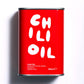 A red tin with white wring in a hand brushed style saying CHILLI OIL in jumbled way. It also states 250ml