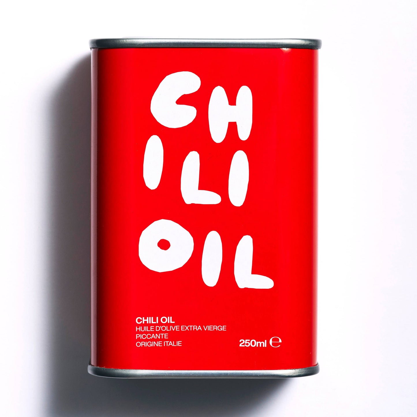 A red tin with white wring in a hand brushed style saying CHILLI OIL in jumbled way. It also states 250ml