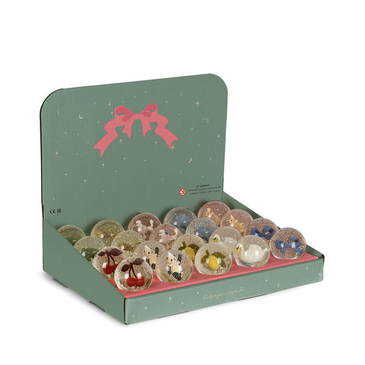 Set of decorative items in a green box with a pink bow on a white background
