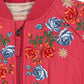 Red jacket with floral embroidery on a red background