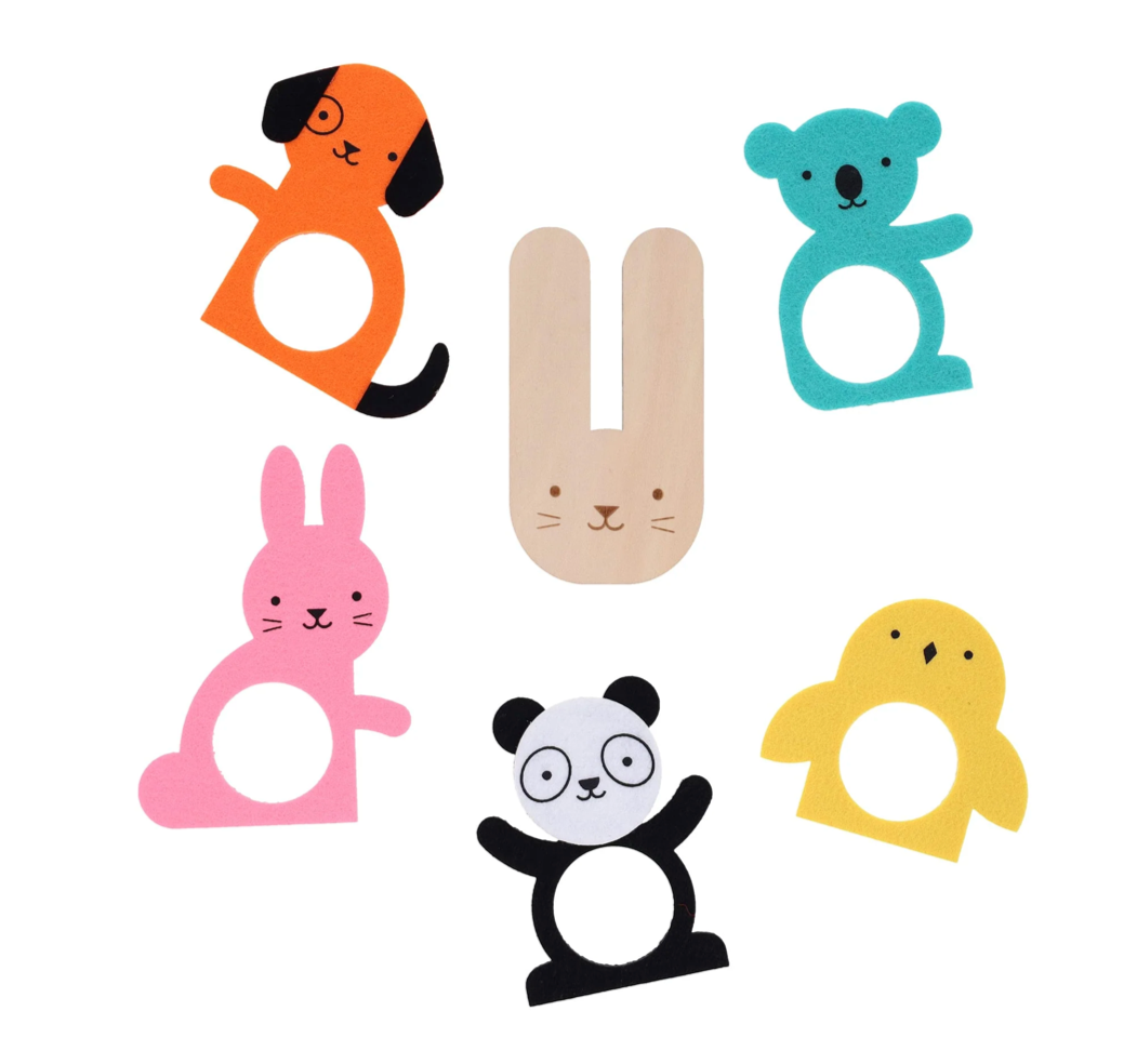 A wooden pom pom maker in the shape of a cute bunny, surrounded by five foam shapes - an orange dog, pink rabbit, black and white panda, yellow chick, blue koala - used to make the pom pom creatures