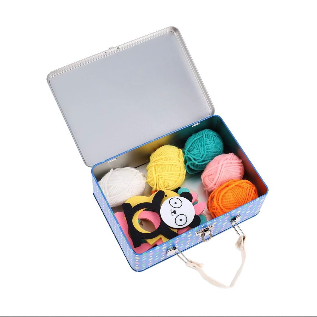 An open tin case showing 5 coloured alls of wool - white, yellow, teal, pink, orange, with a foam panda shape 