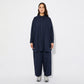 Model wearing the oversized navy cotton shirt with matching wide-leg trousers and chunky grey trainers. The outfit has a monochrome, minimal aesthetic with a relaxed silhouette, as the loose fabric moves naturally with the model's posture.