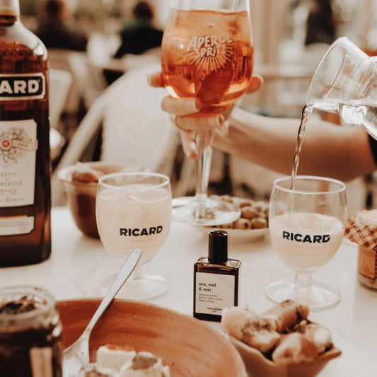 Table setting with Ricard drinks, food, and a bottle of Aperol Prosecco.