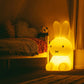 Mr Maria Miffy XL Lamp, 80 cm tall, iconic statement piece with six brightness settings, inspired by Dick Bruna's classic illustrations. It is lit up in a childs darkened  bedroom 