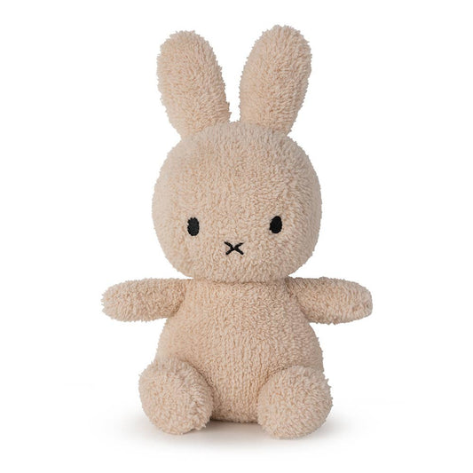 A MiffyTerry soft toy in the colour beige. This Miffy has black eyes and mouth. Miffy is 23 cm in height. The background is white. 