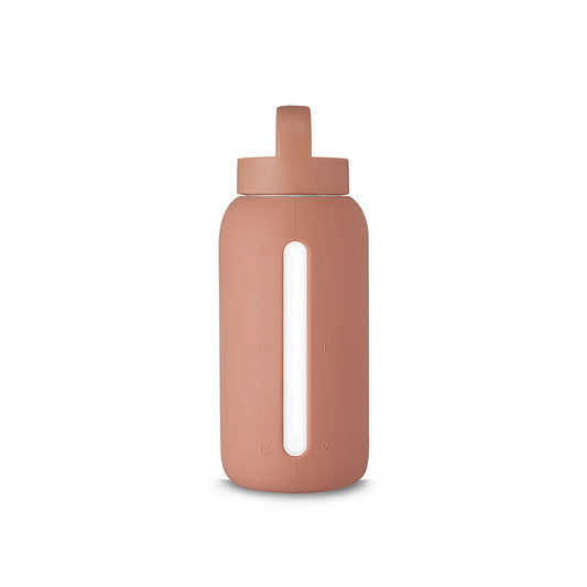 A matte Silicone covered glass bottle, with a window to see the drink on the inside, in a pink clay colour with a plastic screw top circular lid with a handle