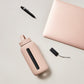 A matte Silicone covered glass bottle, with a window to see the drink on the inside, in a pinky cream colour with a plastic screw top circular lid with a handle
