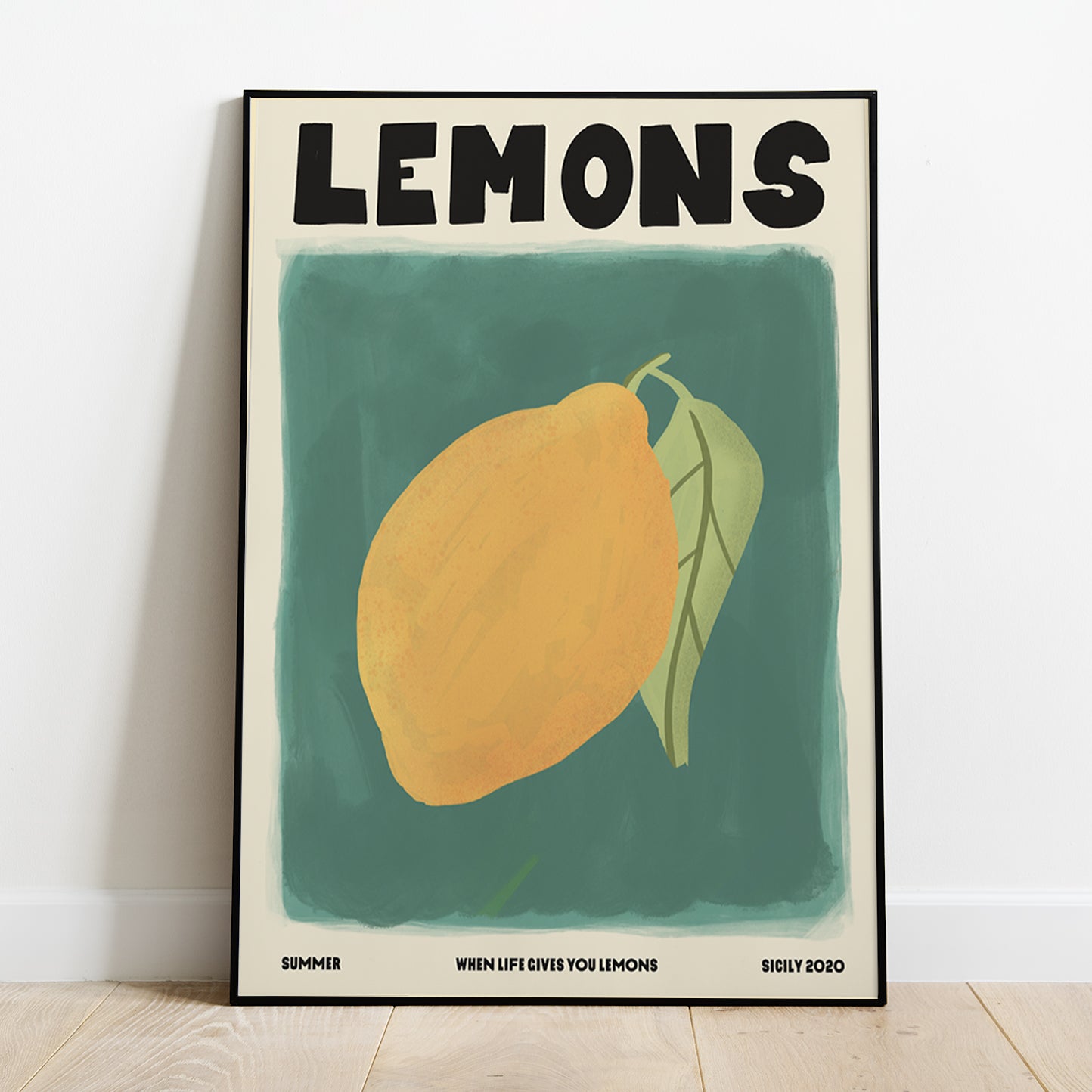 ANatalia Bagniewska lemons prints. The background is dark green in colour. The lemon is yellow with a green stem and green leaf. The leaf has dark green veins. Beneath the green background, in black, on the left hand side it says Summer, in the middle it says When Life Gives You Lemons and on the right hand side it says Sicily 2020. The print is framed and is kept on  wooden floor against a white wall. 