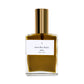 A bottle of Saint Rita Parlor Signature Fragrance Parfum with a golden liquid visible inside, a gold-colored cap, and a white label.