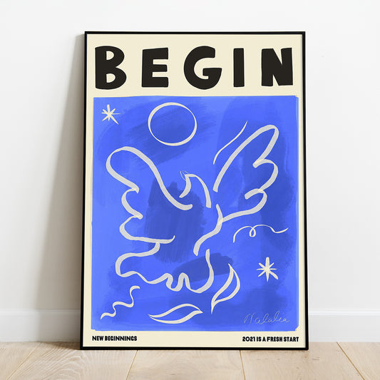 A  Natalia Bagniewska A2 Begin Print of a white bird taking a flight in the sky with stars, the sun and leaves acting as other decorative elements around it in white. Beneath the print it says New Beginnings on the left hand side and 2021 Is A Fresh Start on the right hand side. The background is marine blue. It is framed and is kept against a white wall on a wooden floor. 